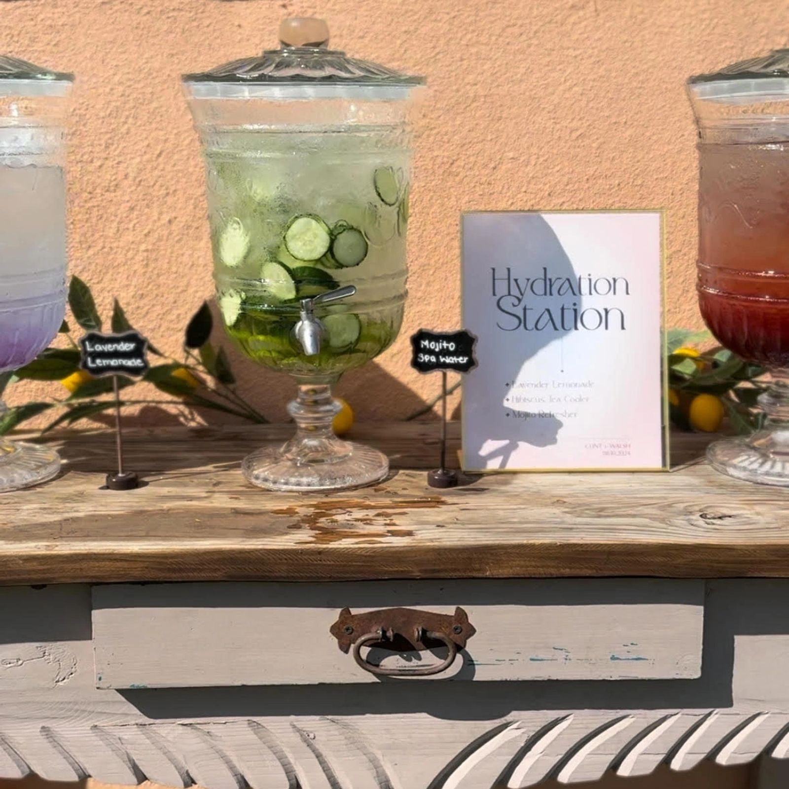 Mobile bar draped in pink and white florals with a row of chilled bottles